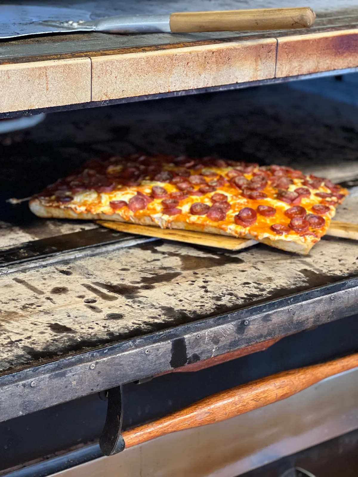 a square pizza coming out of the oven 